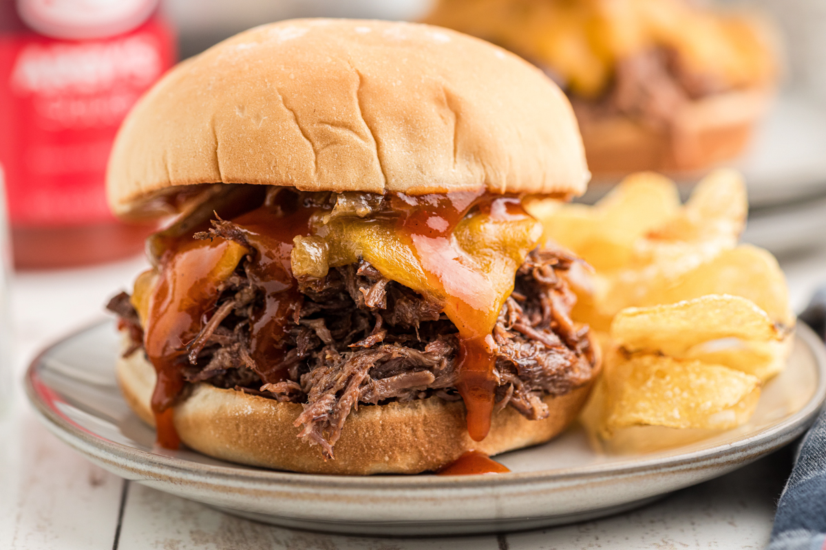 close-up of one of the slow cooker arby's beef and cheddars on a plate.