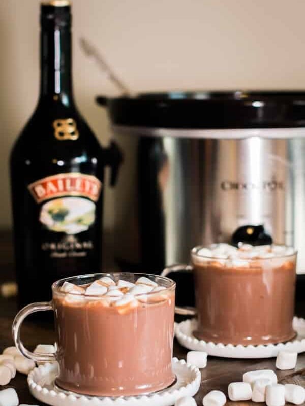 2 cups of baileys hot chocolate with bottle of baileys behind it.
