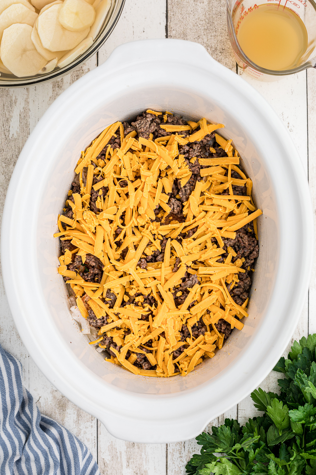 beef and shreded cheese in a crockpot.