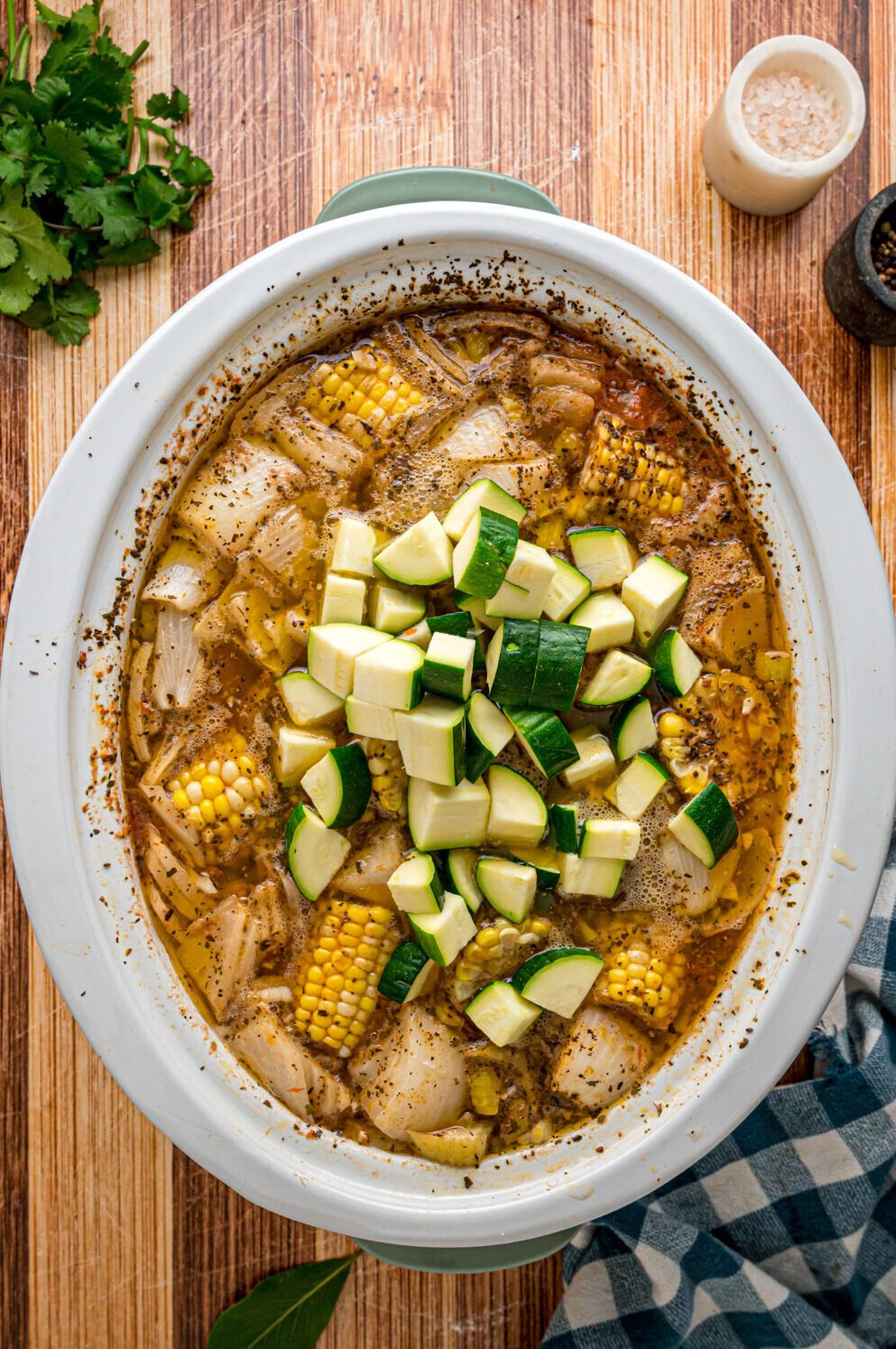 Zucchini added to caldo de pollo in a crockpot.