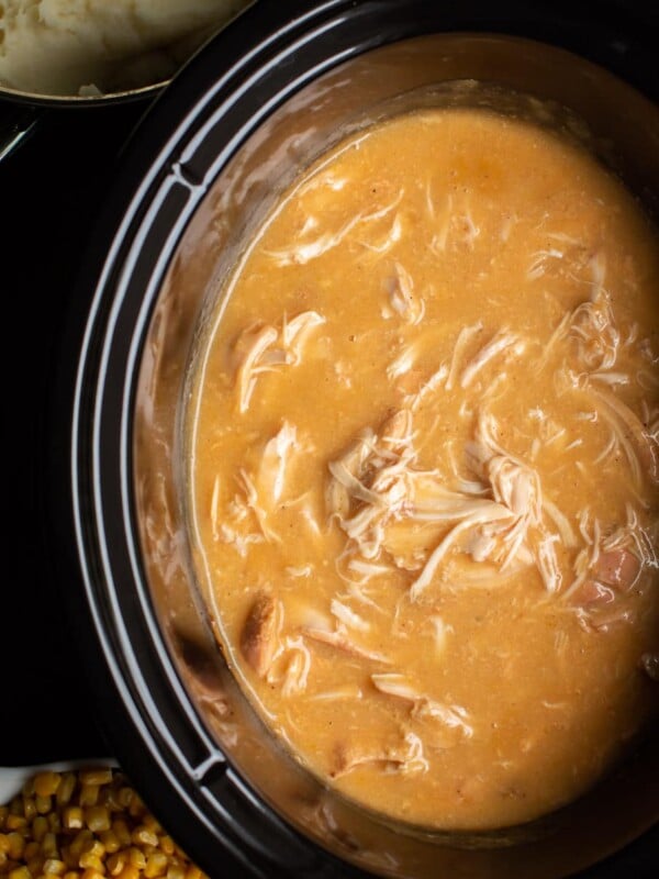 Close up of chicken and gravy in a slow cooker.