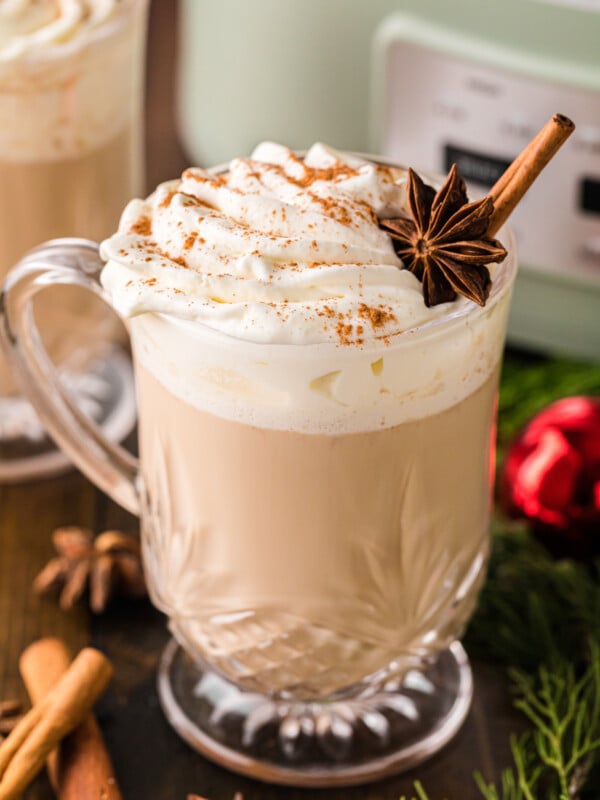 Christmas coffee in a glass mug with whipped cream.