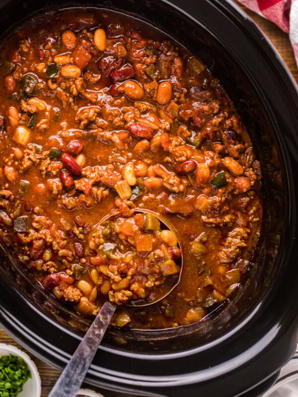 A crockpot of cowboy chili with a ladle in it.