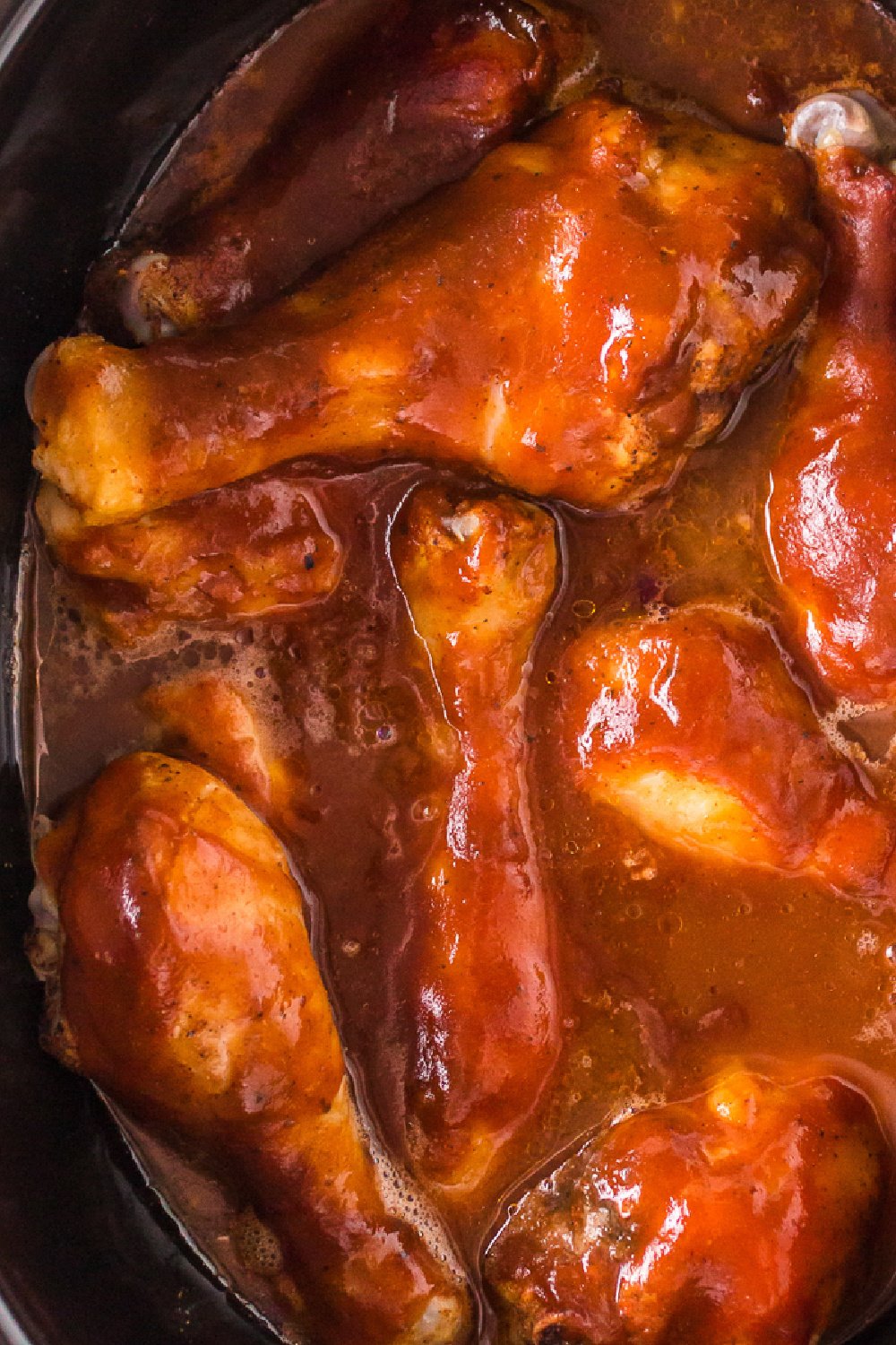 close up of chicken drumsticks in a slow cooker.