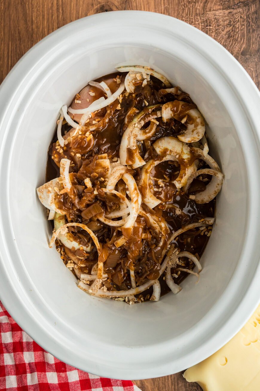 chicken, french onion soup mix, and onion ins a slow cooker.