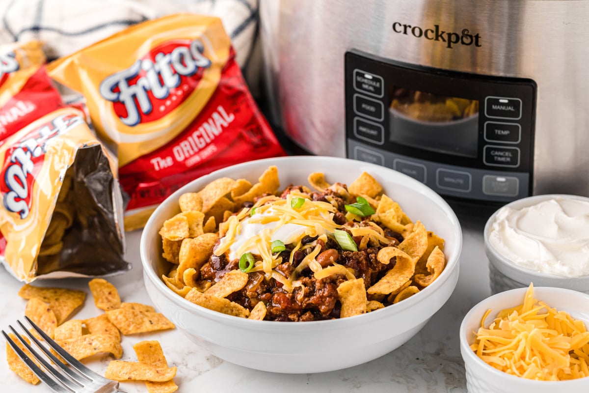serving of slow cooker frito pie in a white bowl.