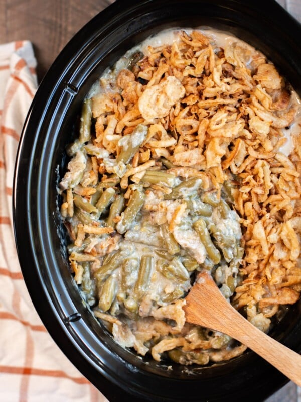 close up of green bean casserole with a spoon in it.