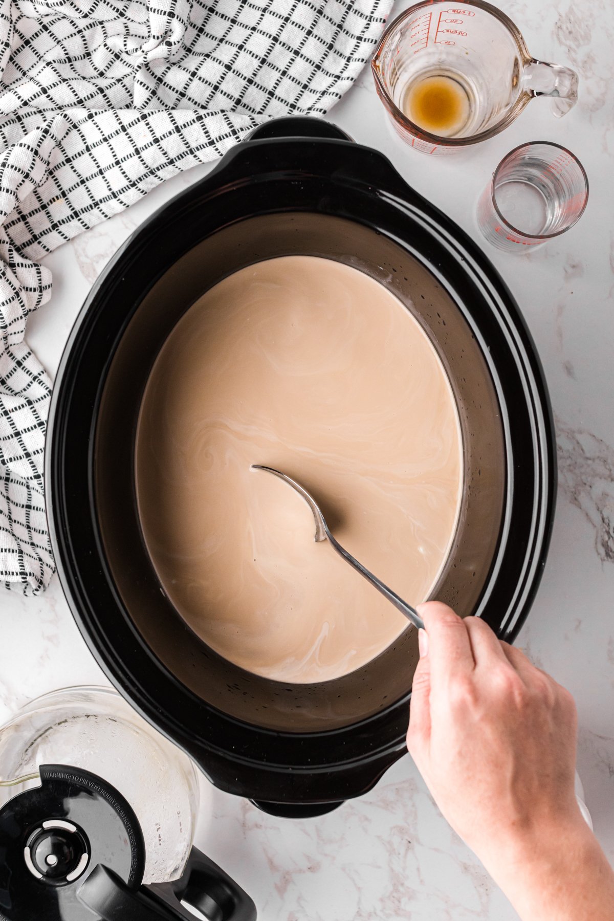 stirring hot white russian mixture in a crockpot before cooking.