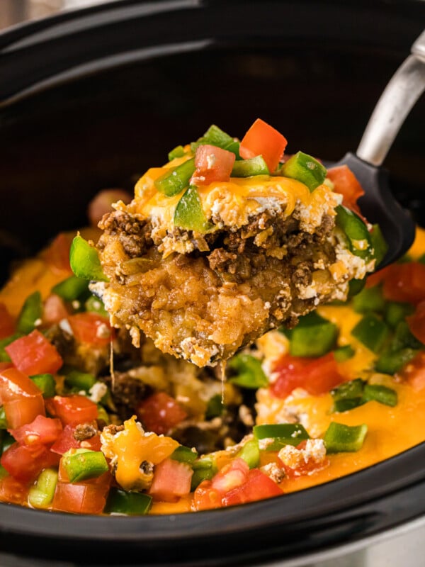 A scoop of John Wayne casserole being scooped out of a crockpot.