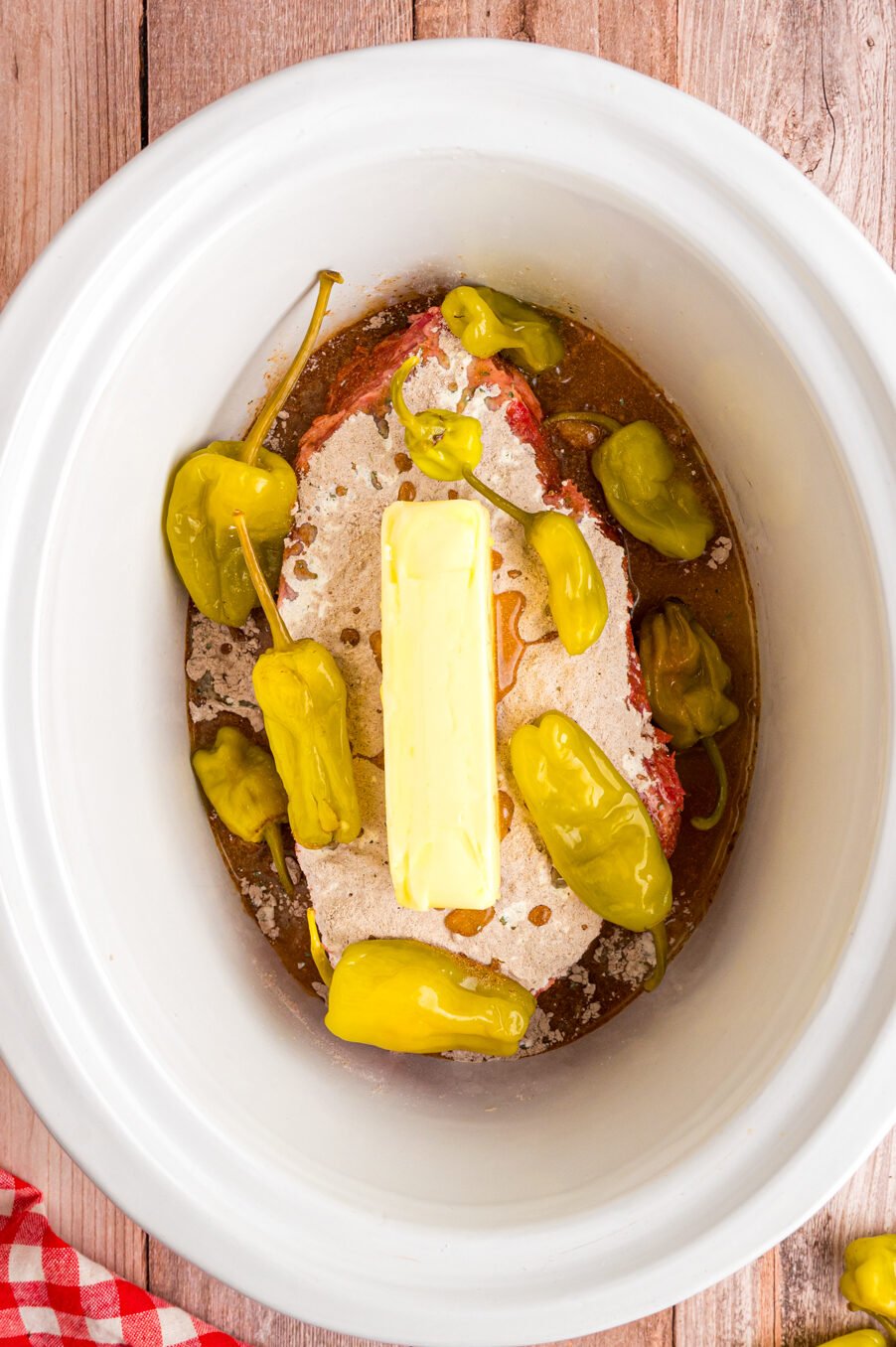 Butter and pepperoncinis added on top of roast in slow cooker.