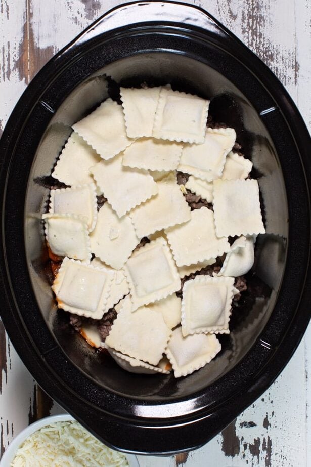 layers of marinara, meat and marinara in slow cooker