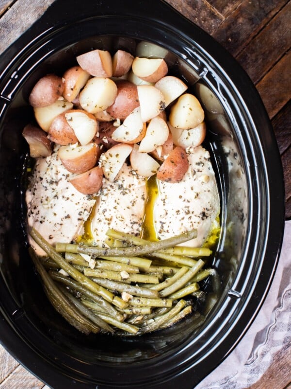 close up photo of chicken, potatoes and green beans in slow cooker