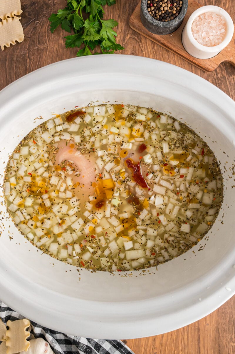 broth, vegetables, chicken, and sun dried tomatoes in a slow cooker for white lasagna soup.