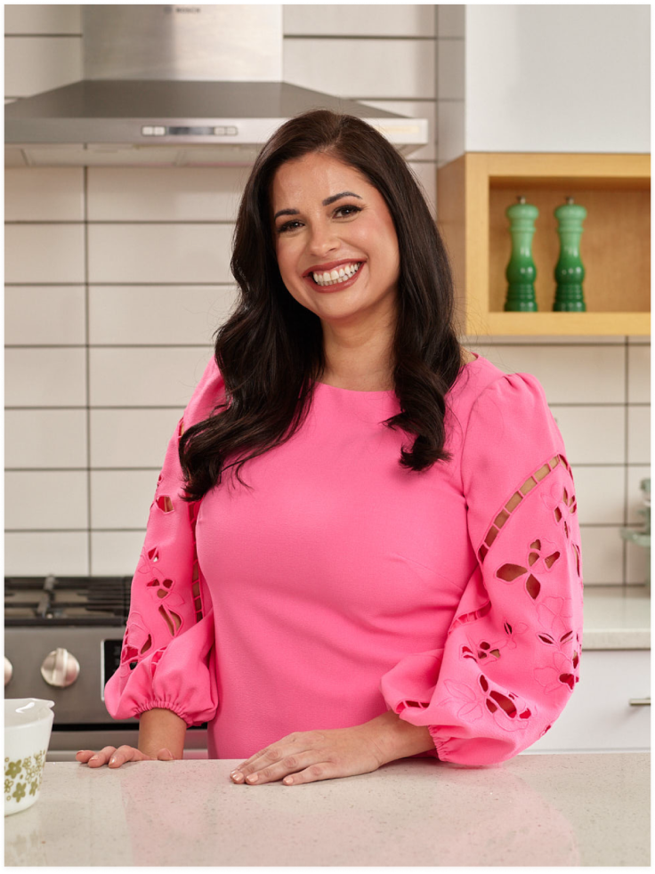 Image of sarah olson in a pink dress in a kitchen.